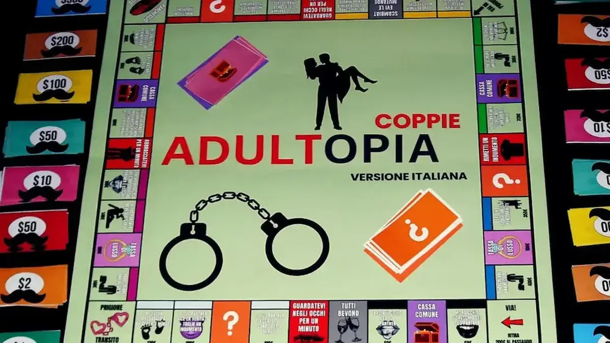 Il tabellone del gioco per adulti Adultopia su un tavolo scuro, con banconote e carte sfida disposte attorno